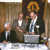 11/5/75 - District Governor Lee Shore’s Official Visitation, Granada Cafe, San Francisco - L to R: Al Gentile, Hugo Checci, Lee Shore, DG; and Joe Farrah. Tail Twister Hugo Checci exacting a fine from the District Governor.