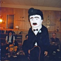 2/18/83 - Convention Prep, at a member’s residence - Handford Clews (guess) modeling Charlie Chaplin costume. L to R: Margot Clews, Emily Farrah, and Ted Zagorewicz.