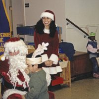 12-20-02 - Mission Education Center Christmas with Santa, Mission Education Center, San Francisco - Al Gentile, left, hands Santa as a student egerly waits. Santa’s assistant holds an approving smile. Other students wait patiently on the right after receiving their presents.