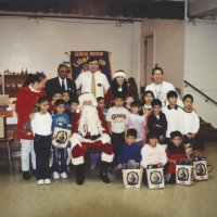 12-20-02 - Mission Education Center Christmas with Santa, Mission Education Center, San Francisco - A class, their teachers, and Dr. Mehendra Dave, 2nd from left in back row, and Sheriar Irani, to his right, pose with Santa and his assistant after receiving their gifts.