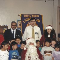 12-20-02 - Mission Education Center Christmas with Santa, Mission Education Center, San Francisco - A class, their teachers, and Dr. Mehendra Dave, 2nd from left in back row, and Sheriar Irani, to his right, pose with Santa and his assistant after receiving their gifts.