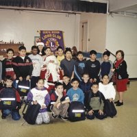12-20-02 - Mission Education Center Christmas with Santa, Mission Education Center, San Francisco - A class has their picture taken with Santa, and his assistant who is way in the back, and their teacher.