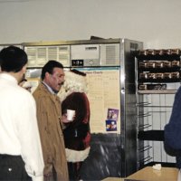 12-20-02 - Mission Education Center Christmas with Santa, Mission Education Center, San Francisco - L to R: Al Gentile (obscured), Sheriar Irani, newly arrived Steve Currier, and Dick Johnson getting some refreshment with Santa and his assistant in the background.