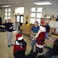 12-20-02 - Mission Education Center Christmas with Santa, Mission Education Center, San Francisco - Discussing present details are, L to R, Sheriar Irani, Steve Currier, Dick Johnson, Santa’s assistant, Aaron Straus, Santa, and Al Gentile.