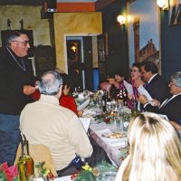 12/8/04 - Club Christmas Party, Ristorante Mar, Pacifica - Members and guests singing Christmas carols, led by Handford Clews. (standing). Next to Handford is Aaron Straus and Diane Donnelly (backs to camera). Opposite side, end of table, is Margot Clews, Kathy & George Salet, and Joe & Emily Farrah.
