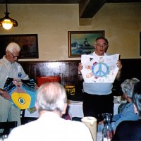 11/10/04 - Granada Cafe - Al Gentile (left) and Aaron Straus displaying two of our entries in the Peace Poster Contest. The participating schools were Corpus Christi, St. Elizabeth, St. John and Cornerstone Academy. The theme for this year's competition was “Give Peace A Chance.” Attentive Lion members look on the display.