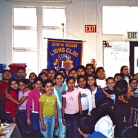 11/22/05 - Mission Educational Center, San Francisco - Students crowd in for a group shot with our Club banner. Lion Bob Lawhon patiently waits in front of the banner for them to get set.