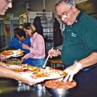 11/22/05 - Mission Educational Center, San Francisco - L to R: Lion Lyle Workman, cafeteria staff, and Lions Bre Martinez and Aaron Straus preparing plates for the students.