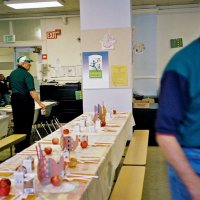 11/22/05 - Mission Educational Center, San Francisco - Lion Joe Farrah, left, making sure all the setting have a carton of milk. Lion Al Gentile, right, hurries to complete the table settings.