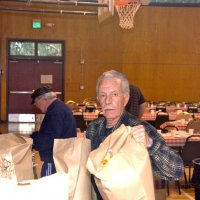 2/23/08 - 26th Annual Crab Feed - Janet Pomeroy Recreation & Rehabilitation Center, San Francisco - Mike Castagnetto, chief cook, bring in teh french rolls, with Bob Lawhon, and others, working in the background.