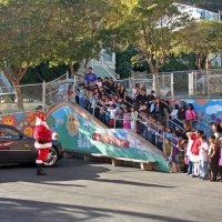 12/18/09 - Christmas with Santa, Mission Education Center, San Francisco - Officer Ignacio “Natcho” Martinez as Santa - Santa saying hello to the children while his helper gets out of the back seat.