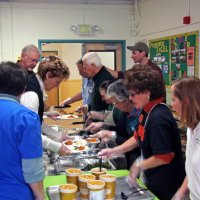 11/20/09 - Thanksgiving Luncheon, Mission Education Center, San Francisco - Preparing plates are, front to back, left: staff, Diane & Dick Johnson; right: Bre Jones, Emily Powell Palmer, Emily Farrah, staff, Al Gentile, and George Salet.