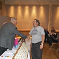 11/28/10 - 32nd Annual Giulio Francesconi Charity Raffle - Upstairs Ballroom, Italian American Social Club, San Francisco - Dick Johnson, left, congratulates a winner. Back, near column, is Diane Johnson; to right of winner is Bre Jones and Estelle Bottarini.