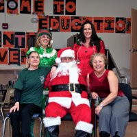 12/17/10 - Annual Christmas with Santa - Mission Education Center, San Francisco - A cafeteria worker and an assistant teacher pause to pose with Santa and his Elves.