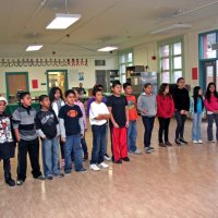 12/17/10 - Annual Christmas with Santa - Mission Education Center, San Francisco - A larger class, perhaps fifth graders, lines up to greet Santa and his Eleves.