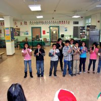 12/17/10 - Annual Christmas with Santa - Mission Education Center, San Francisco - A class, perhaps fourth graders, performs their musical number using recorders, as Santa and his Eleves look on.