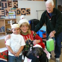 12/16/11 - Annual Christmas with Santa - Mission Education Center, San Francisco - Ms. Linda as Santa, with her dog Emma - Each student takes turns posing with Santa. Al Gentile, on right, hands Santa a gift for each student.