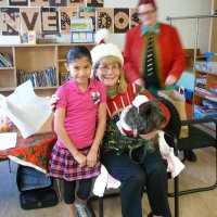 12/16/11 - Annual Christmas with Santa - Mission Education Center, San Francisco - Ms. Linda as Santa, with her dog Emma, and Jackie Cash as her Elf - Each student takes turns posing with Santa. A blury Al Gentile in the background.