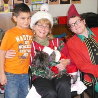 12/16/11 - Annual Christmas with Santa - Mission Education Center, San Francisco - Ms. Linda as Santa, with her dog Emma, and Jackie Cash as her Elf - Each student takes turns posing with Santa.