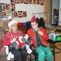 12/16/11 - Annual Christmas with Santa - Mission Education Center, San Francisco - Ms. Linda as Santa, with her dog Emma, and Jackie Cash as her Elf - Al Gentile arranging gift bags in the background.