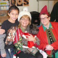 12/16/11 - Annual Christmas with Santa - Mission Education Center, San Francisco - Ms. Linda as Santa, with her dog Emma, and Jackie Cash as her Elf - Each student takes turns posing with Santa.