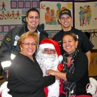 12-21-12 - Christmas with Santa at Mission Educational Center, San Francisco - School staff pose with Santa and a couple of his firefighter escort.