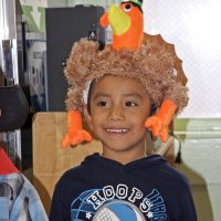 11-16-12 - Thanksgiving Luncheon, Mission Educational Center, San Francisco - A srudent proudly wears his turkey hat, the center of his class’ song.