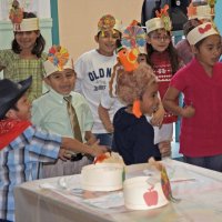 11-16-12 - Thanksgiving Luncheon, Mission Educational Center, San Francisco - The student in the turkey hat enjoys being the center of attention as his classmates sing about the turkey.