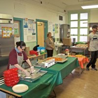 11-16-12 - Thanksgiving Luncheon, Mission Educational Center, San Francisco - With the presentations about done, luncheon is ready to be plated. May Wong in back with purple shirt.