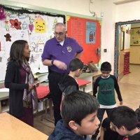 12-15-16 - Christmas with Santa with the help of Los Bomberos Firefighters, Mission Education Center, San Francisco - Aaron Straus talks with a teacher as students wait their turn with Santa.