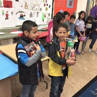 12-15-16 - Christmas with Santa with the help of Los Bomberos Firefighters, Mission Education Center, San Francisco - Students cling to their gifts from Santa after receiving them.