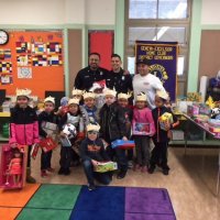 12/21/17 - Christmas with Santa, Mission Educational Center - School children pose with their gifts from Santa with San Francisco Firemen.