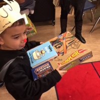 12/21/17 - Christmas with Santa, Mission Educational Center - A very happy school child with his Spanish language book and Hot Wheels received from Santa.