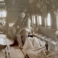 1951: Corporal Joseph Farrah, wearing a parachute, being transported in a C-47 from Seoul to Susan, South Korea. Joe was assigned to the war crimes section where they investigated and documented atrocities being perpetrated by the enemy.