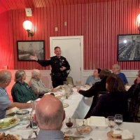 9/19/18 - Guest speaker SFPD Capt. Jack Hart, Italian American Social Club - Capt. Jack Hart giving his remarks. From left: Lions George Salet, Paul Corvi, Joe Farrah, Capt. Jack Hart, four guests of Lion Sharon Eberhardt (dark hair facing Capt. Jack), and Lion Zenaida Lawhon. Nice shot of the back of Lion Bill Graziano’s head.