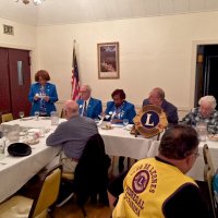 10/17/18 - District Governor's Visitation, Italian American Social Club - L to R outside of table: Lions Al Gentile, Zone Chair Jessie Peoples, Regional Chair Richard Loewen, District Governor Lydia Taylor-Bellinger, President George Salet, and Secretary Joe Farrah. Inside table: Lion Bill Graziano (gray shirt), and visiting Lion Hernaldo Martinez from Pedregal, Panama (in vest.) Lion Zone Chair Jessie Peoples introducing Regional Chair Richard Loewen.