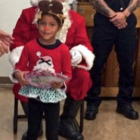 12/18/18 - Los Bomberos Firefighters with Santa at Mission Education Center - A happy kindergarten student, with her gift from Santa.