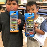 12/18/18 - Los Bomberos Firefighters with Santa at Mission Education Center - two proud first grade students showing off their Hot Wheels gifts from Santa.