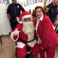 12/18/18 - Los Bomberos Firefighters with Santa at Mission Education Center - Lion Zenaida Lawhon takes a quick pose with Santa between classes.