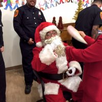 12/18/18 - Los Bomberos Firefighters with Santa at Mission Education Center - Lion Zenaida Lawhon cooling off Santa between classes.