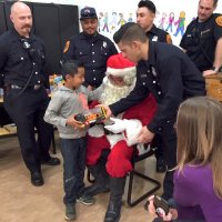 12/18/18 - Los Bomberos Firefighters with Santa at Mission Education Center - A happy third grader receiving his gift from Santa.