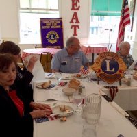 7/3/19 - Lions meeting, IASC - L to R: Lions Zenaida Lawhon, Sharon Eberhardt, President George Salet, and Secretary Joe Farrah reading minutes of the previous Board meeting. Pennant flags provided by Lions Bob and Zenaida Lawhon.