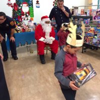 12/13/19 - Mission Education Center Christmas with Santa and Los Bomberos Firefighters - one of the 200 students eyeing his gift after receiving it from Santa.