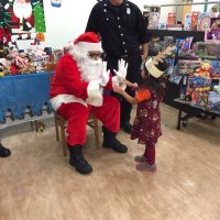 12/13/19 - Mission Education Center Christmas with Santa and Los Bomberos Firefighters - one of the 200 students inspecting Santa’s hands and making sure he has nothing up his sleve before receiving her gift from Santa.