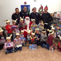 12/13/19 - Mission Education Center Christmas with Santa and Los Bomberos Firefighters - one of the school classes proudly posing with Santa and members of Los Bomberos Firefighters after receiving their gifts from Santa.