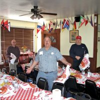2/23/19 - 34th Annual Crab Feed - Putting on the finishing touch, the crab bibs, are L to R: Lions Bill Graziano, President George Salet, and chairman Bob Fenech.