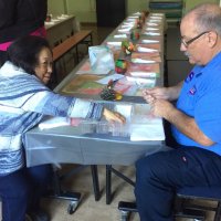 11/21/19 - Mission Education Center Thanksgiving Luncheon - Lion President George Salet (right), with another volunteer, preparing place settings prior to serving luncheon to 230 students.