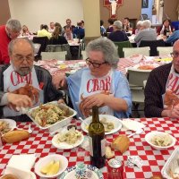 2/8/20 - 35th Annual Crab Feed at St. Philip the Apostle Church - by Lion Bob Lawhon - Lion Bill Graziano, on the right, with some of his guests, Rose Ann Harris (in red sweater, working non-stop) with the Lion Sharon Eberhardt and Lion George Salet tables in the background.