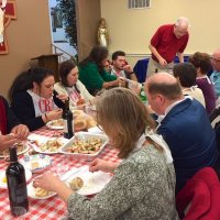 2/8/20 - 35th Annual Crab Feed at St. Philip the Apostle Church - by Lion Bob Lawhon - One end of the Lion George Salet teble (seated in blue shirt at end); Lion Lyle Workman delivering another tray of crab to the table.