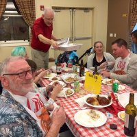 2/8/20 - 35th Annual Crab Feed at St. Philip the Apostle Church - by Lion Bob Lawhon - Lion Lyle Workman delivering empty trays for crab waste to the end of the Lion George Salet table.